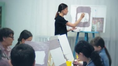 Sanat Okulu, yaratıcılık ve insanlar kavramı - grup öğrenci Sephalar, boya fırçaları ve stüdyoda, natürmort resim paletleri ile yaşlı ve genç insanlar çizmek