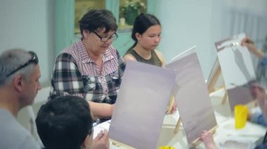 Sanat Okulu, yaratıcılık ve insanlar kavramı - grup öğrenci Sephalar, boya fırçaları ve stüdyoda, natürmort resim paletleri ile yaşlı ve genç insanlar çizmek