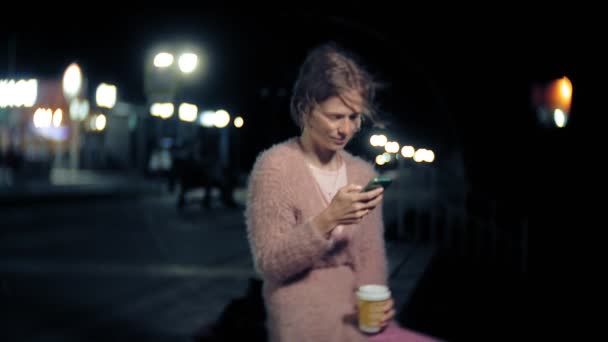젊은 여자 텍스트 밤에 시내 동안 휴대 전화에 메시지. 도시에서 스마트폰으로 행복 여성 문자. — 비디오