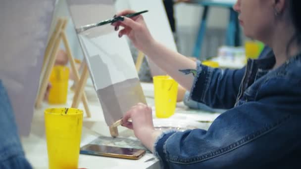 Scuola d'arte, creatività e concetto di persone - gruppo di studenti con cavalletti, pennelli e tavolozze che dipingono nature morte in studio, vecchi e giovani disegnano — Video Stock