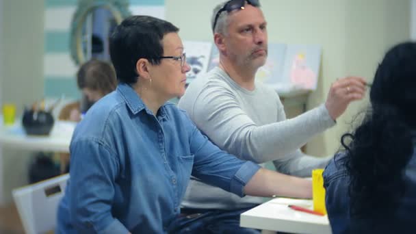 Kunstschule, Kreativität und Menschenkonzept - Schülergruppe mit Staffeleien, Pinseln und Paletten malt Stillleben im Atelier, Alte und Junge zeichnen — Stockvideo