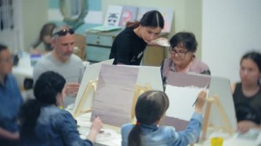 Sanat Okulu, yaratıcılık ve insanlar kavramı - grup öğrenci Sephalar, boya fırçaları ve stüdyoda, natürmort resim paletleri ile yaşlı ve genç insanlar çizmek