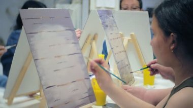 Sanat Okulu, yaratıcılık ve insanlar kavramı - grup öğrenci Sephalar, boya fırçaları ve stüdyoda, natürmort resim paletleri ile yaşlı ve genç insanlar çizmek