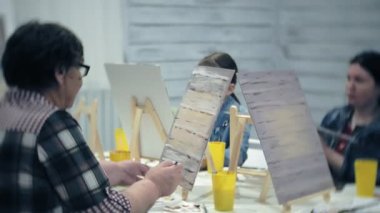 Sanat Okulu, yaratıcılık ve insanlar kavramı - grup öğrenci Sephalar, boya fırçaları ve stüdyoda, natürmort resim paletleri ile yaşlı ve genç insanlar çizmek