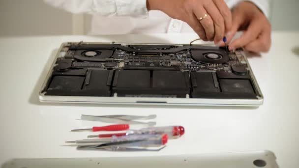 Un hombre está reparando un portátil. El concepto de reparación de computadoras. Primer plano de hombre reparación placa base portátil con un destornillador. Mantenimiento del hardware de la placa base. Soporte de disco, reparación de computadoras — Vídeos de Stock