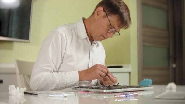 Un hombre está reparando un portátil. El concepto de reparación de computadoras. Primer plano de hombre reparación placa base portátil con un destornillador. Mantenimiento del hardware de la placa base. Soporte de disco, reparación de computadoras — Vídeos de Stock