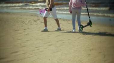 Gençler bir scooter ile sahilde yürüyüş