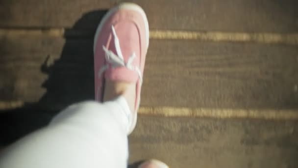 Primer plano de las piernas de las mujeres en zapatillas brillantes, que poco a poco pisó la arena mojada, probablemente junto al mar o el río . — Vídeo de stock