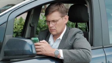 Arabada olgun işadamı smartphone kullanır