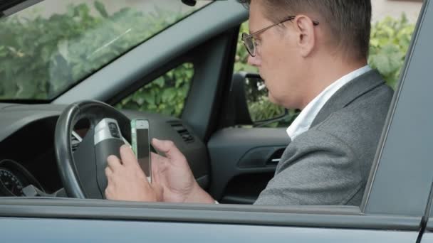 Homem de negócios maduro no carro usa smartphone — Vídeo de Stock