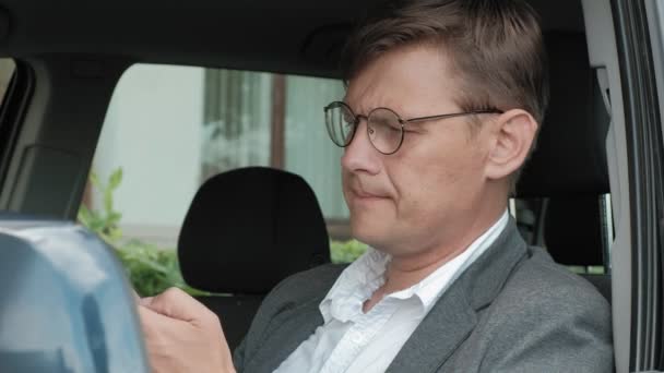 Rijpe zakenman in auto maakt gebruik van smartphone — Stockvideo