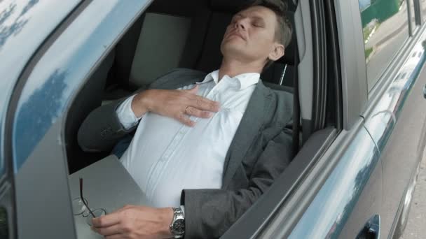 Mature businessman in the car lies on the decomposed front seat — Stock Video