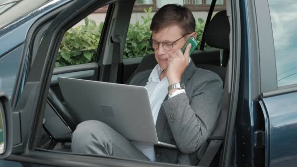 Maduro hombre de negocios en el coche hablando por teléfono — Vídeos de Stock