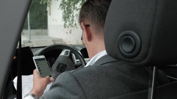 Reifer Geschäftsmann im Auto nutzt Smartphone — Stockvideo