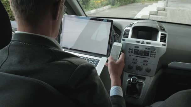 Dizüstü bilgisayarda çalışan arabada olgun iş adamı — Stok video