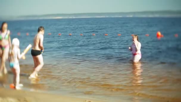 Niños felices están saltando en las olas del mar . — Vídeo de stock