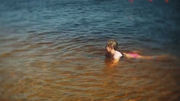 De gelukkige kinderen zijn springen in de golven van de zee. — Stockvideo