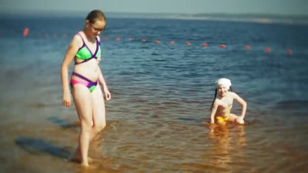 Glada barn hoppar i havet vågor. — Stockvideo