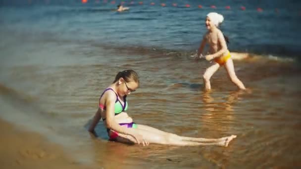 Boldog gyermekek beugrott a tenger hullámai. — Stock videók