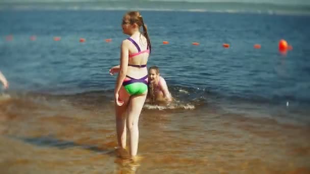 Enfants heureux sautent dans les vagues de la mer . — Video