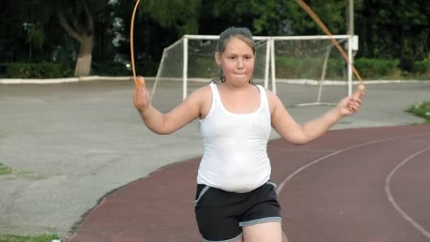 Kis kövér lány jumping kötelet a stadionban — Stock videók