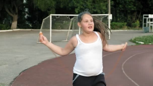 Trochę tłuszczu dziewczyna skakanka na stadionie — Wideo stockowe