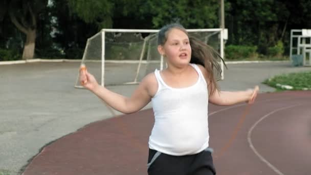 Little fat girl jumping rope in the stadium — Stock Video