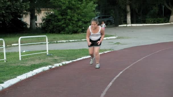 A kis kövér lány fut a stadion — Stock videók