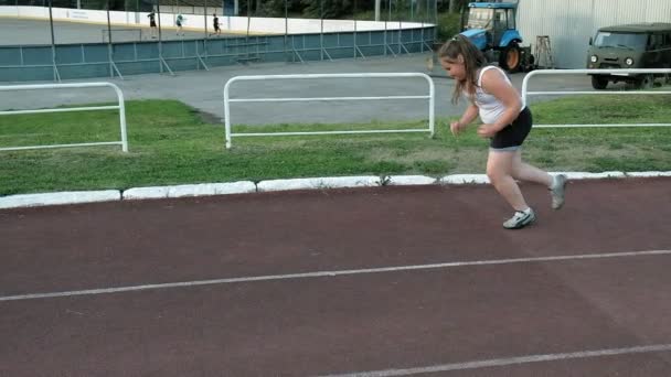 Pequena menina gorda corre no estádio — Vídeo de Stock