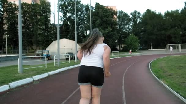 Malá tlustá holčička běží na stadionu — Stock video