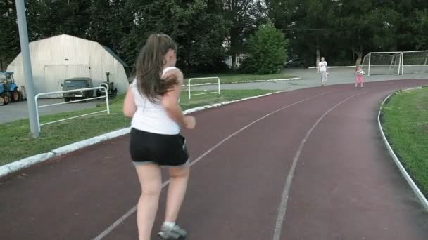 Pequena menina gorda corre no estádio — Vídeo de Stock