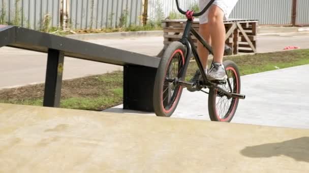 Bir çocuk Bmx Bisiklet hileler kaykay parkı güneşli bir günde biniyor. Çok yavaş hareket — Stok video