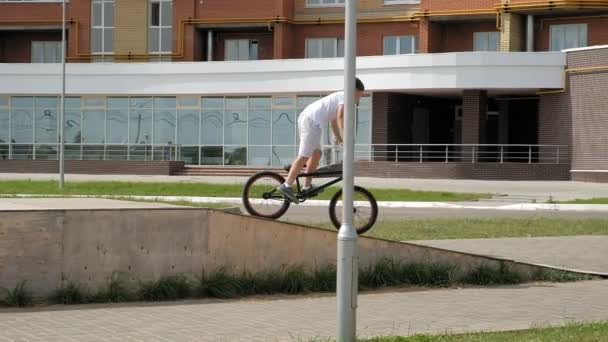 En pojke ridning Bmx cykling tricks i en skateboardpark på en solig dag. Super Slow Motion — Stockvideo