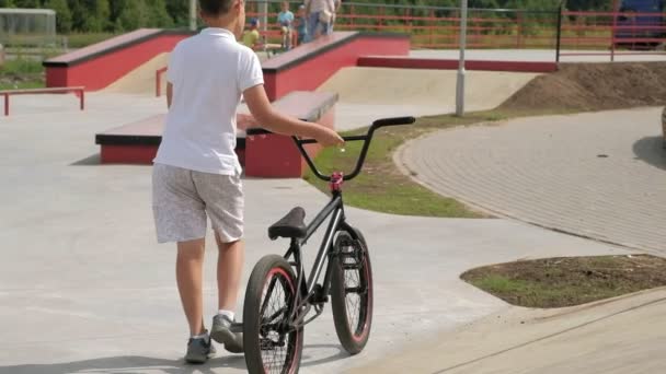 En pojke ridning Bmx cykling tricks i en skateboardpark på en solig dag. Super Slow Motion — Stockvideo