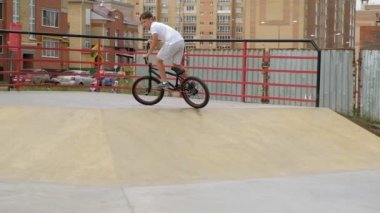 Bir çocuk Bmx Bisiklet hileler kaykay parkı güneşli bir günde biniyor. Çok yavaş hareket