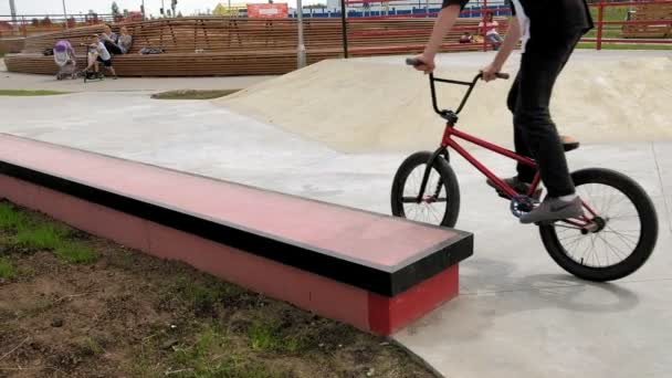 Ein Junge reitet an einem sonnigen Tag in einem Skateboard-Park seine Tricks mit dem Fahrrad. Superzeitlupe — Stockvideo