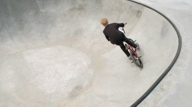 Bir çocuk Bmx Bisiklet hileler kaykay parkı güneşli bir günde biniyor. Çok yavaş hareket