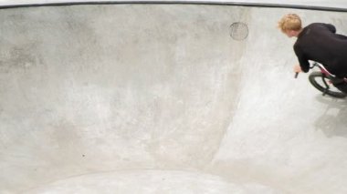 Bir çocuk Bmx Bisiklet hileler kaykay parkı güneşli bir günde biniyor. Çok yavaş hareket