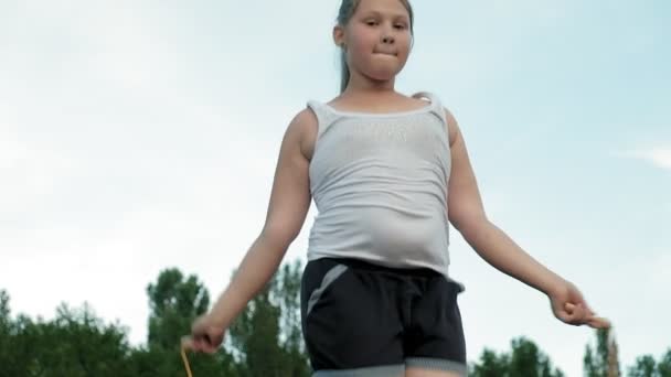 Little fat girl jumping rope in the stadium — Stock Video