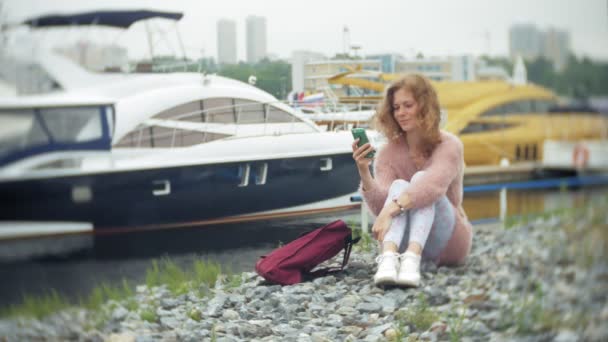 在海滨、游艇和海港航行中使用智能手机的女孩. — 图库视频影像