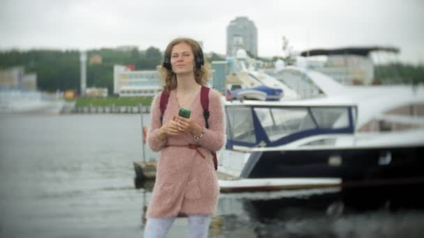 Una ragazza che utilizza uno smartphone al mare, yacht e vela nel porto . — Video Stock
