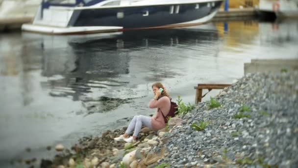 En flicka med en smartphone på seaside, yacht och segling i hamnen. — Stockvideo