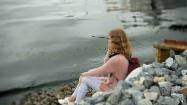 Una chica usando un teléfono inteligente en la playa, yate y vela en el puerto . — Vídeos de Stock