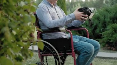 Bir tekerlekli sandalye Engelli bir erkekte bir sanal gerçeklik kask Giydir