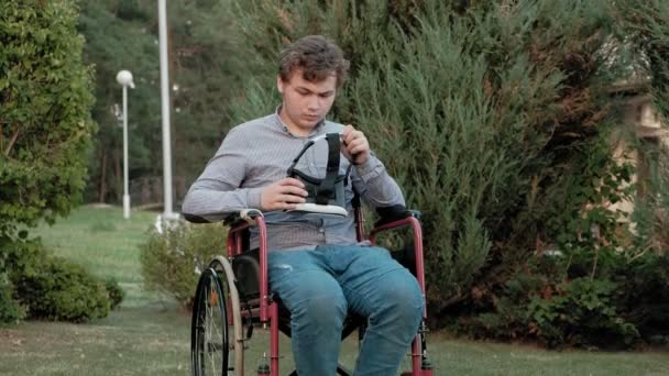 Un uomo disabile su una sedia a rotelle veste un casco realtà virtuale — Video Stock