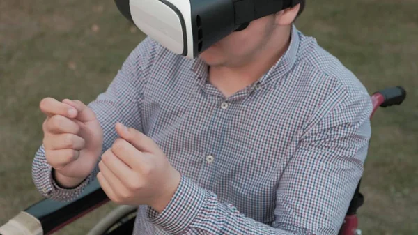 A disabled man in a wheelchair chair uses a virtual reality helmet