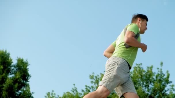Olgun erkek fitness açık havada kulaklık bek devreye girer. Çok yavaş hareket — Stok video