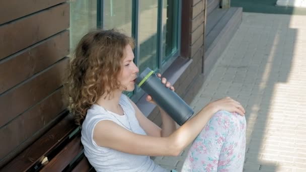 Femme sportive buvant une bouteille d'eau dans un parc au ralenti — Video