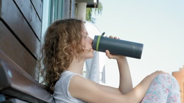 Deportiva bebiendo una botella de agua en un parque en cámara lenta — Vídeos de Stock