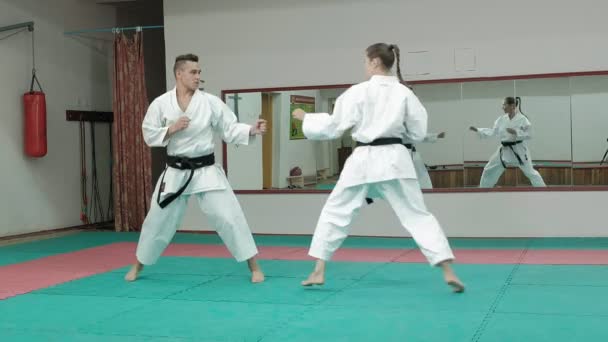 Egy fiatal ember, izmos test, és egy nő gyakorló harcművészetek Goju-Ryu Karate-Do — Stock videók